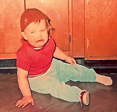 Toddler with brownie hat crying on floor. 
