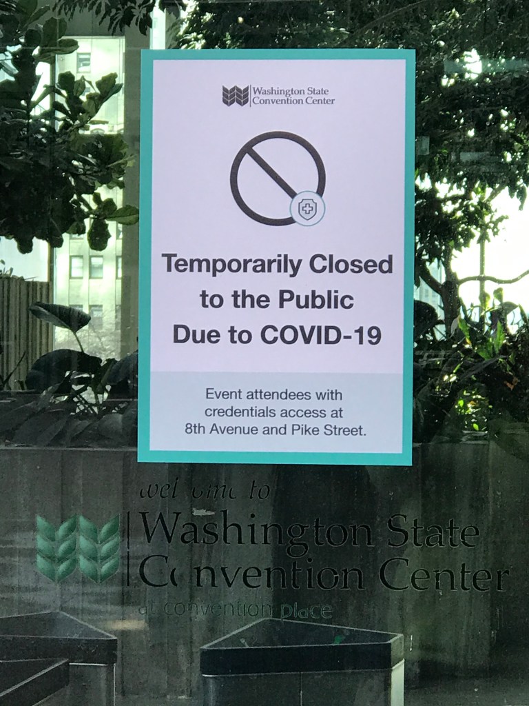 Sign taped to window reading "Temporarily Closed to Public" Washington State Convention Center. 